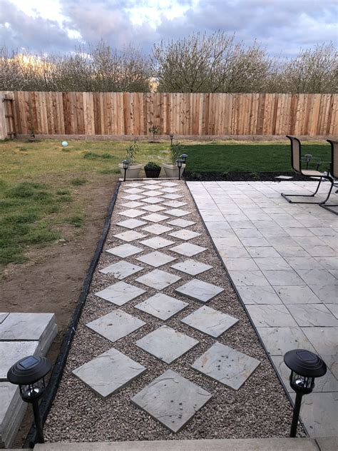 Backyard pathway designed with diagonally places pavers and pebble rocks. | Small backyard ...