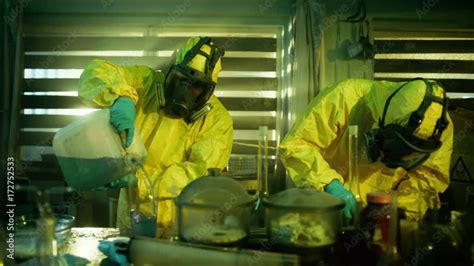 In the Underground Drug Laboratory Clandestine Chemists Wearing Protective Masks and Coveralls ...