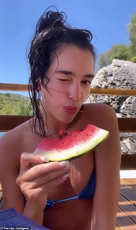 Makeup-free Dua Lipa wears a blue bikini as she films herself eating a pepper-sprinkled ...