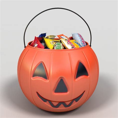 a pumpkin bucket filled with candy and candies on top of a gray background,