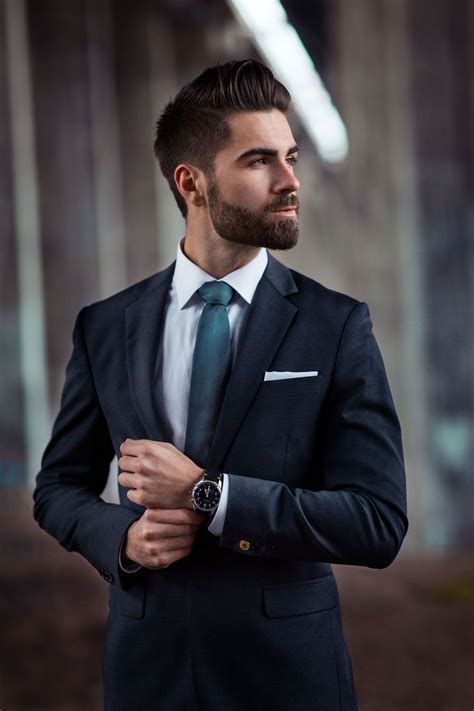 a man in a suit and tie standing with his arms crossed