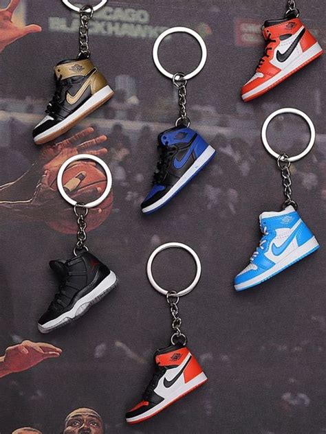 a bunch of shoes that are on a keychain in front of a poster