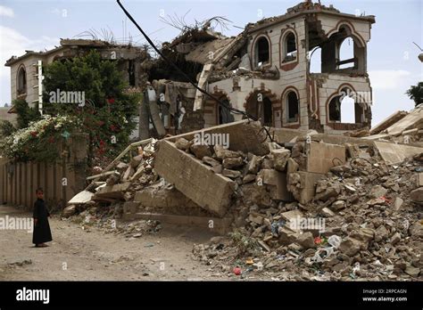 (190629) -- SANAA, June 29, 2019 -- A child walks by a house destroyed during the ongoing war in ...