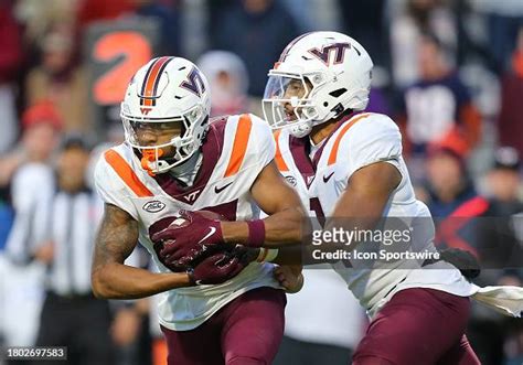 Virginia Tech Hokies quarterback Kyron Drones hands the ball to wide ...