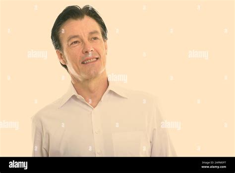 Studio Shot Of Happy Mature Handsome Man Smiling While Thinking Stock Photo Alamy