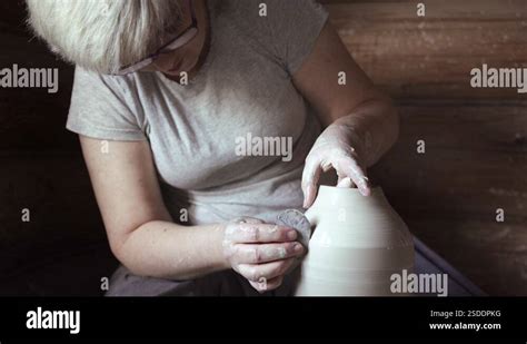 Female Potter Making A Clay Pot On A Pottery Wheel In A Workshop Stock