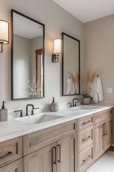 A Bathroom With Two Sinks Mirrors And Lights On The Wall Above Them Is