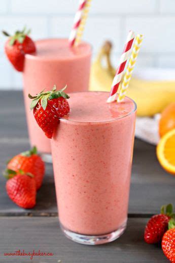 Two Glasses Filled With Strawberry Smoothie And Strawberries On The