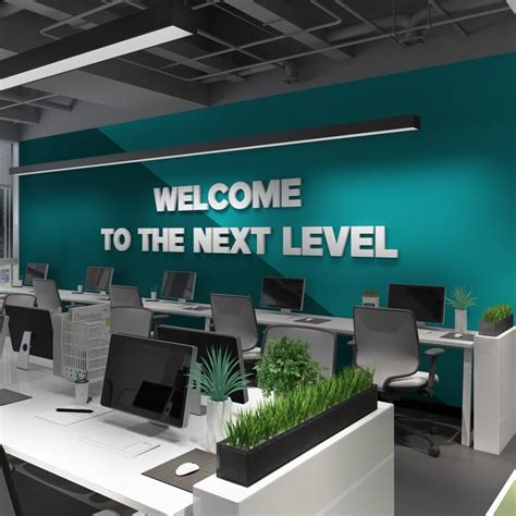 An Office With Desks Computers And Plants On The Wall That Says