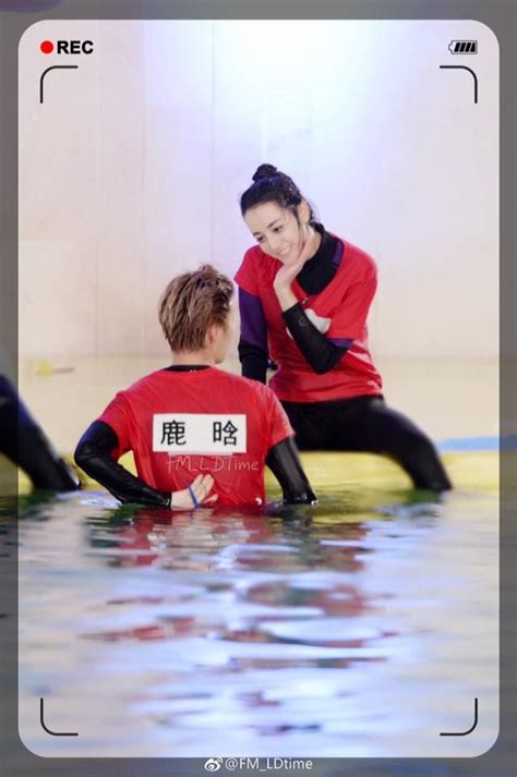 Two People Sitting On Surfboards In The Water With Their Hands Together