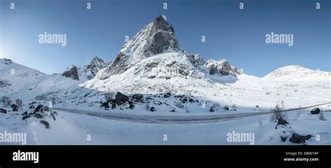 Panorama of snowy mountain range with blue sky and highway in Nordland ...