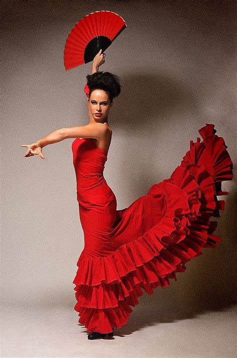 A Woman In A Red Dress Is Dancing With A Fan On Her Head And Arm