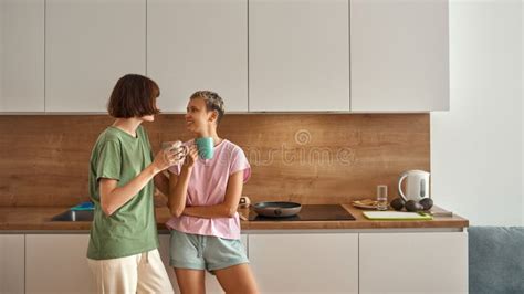 Young Lesbian Girls Drink Tea From Cups At Kitchen Stock Image Image