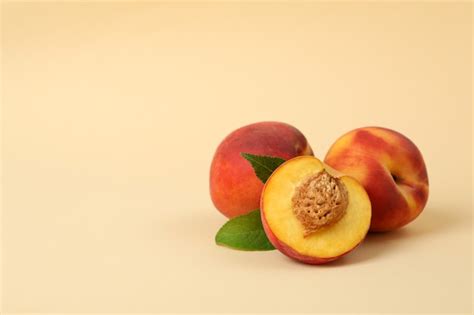 Premium Photo Ripe Peach Fruits With Leaves On Beige Background