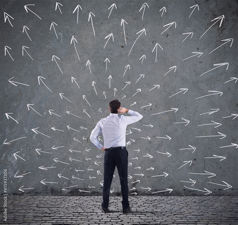 Confused Businessman Looking A Wall With Directional Arrows Concept Of