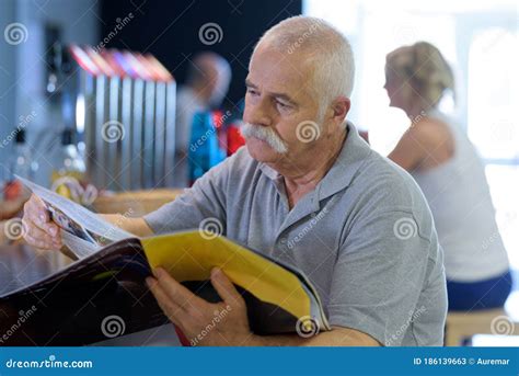 Elderly Man Reading Magazine In Cafe Stock Image Image Of Page