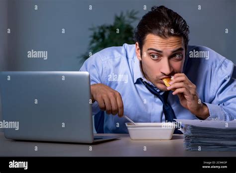 Hungry Employee Working Late In Office Stock Photo Alamy