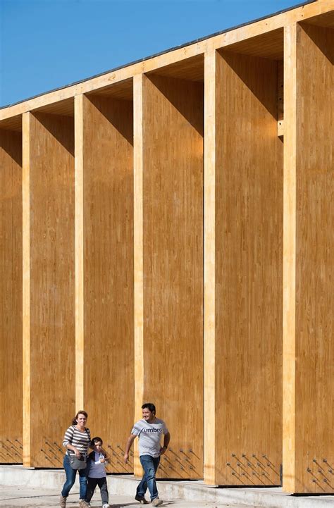 Two People Are Standing In Front Of Some Wooden Walls That Are Being