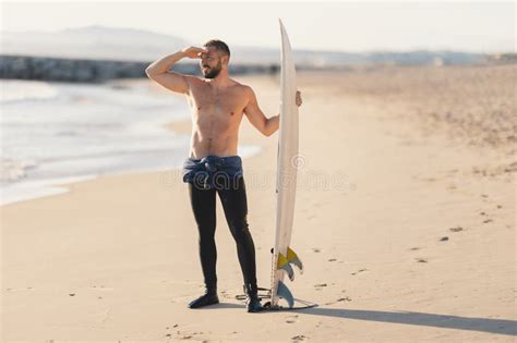 An Athletic Man Surfer With Naked Torso Looking In The Distance Stock