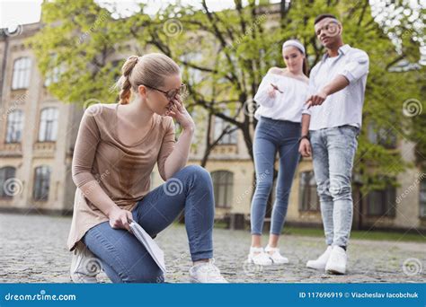 Two Rude Students Bulling Blonde Haired Pleasant Girl Stock Image