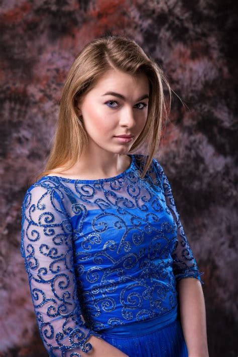 Elegant Blonde Woman In The Blue Evening Sparkling Dress Is Posing On