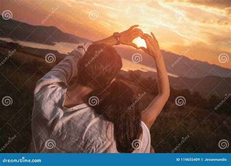 Couple in Love Making a Heart - Shape with Hands, Looking at the Sunset ...