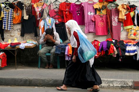 An Old Palestinian Woman Walks In Al Maghazi Refugee Camp Market