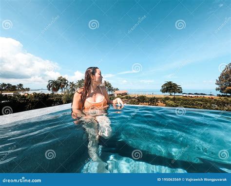 Asian Woman In Bikini In Infinity Swimming Pool Edge Luxury Vacation