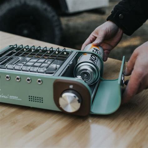 a person is using an electronic device on a wooden table with other ...