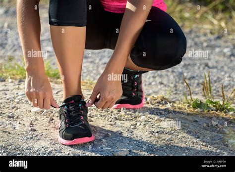 Attractive Female Runner Tying Her Shoe Laces Stock Photo Alamy