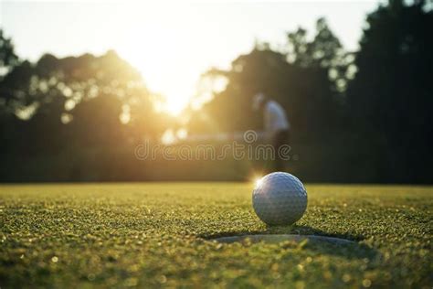 Blurred Golfer Playing Golf In The Evening Golf Course On Sun Set