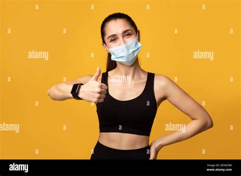 Woman Wearing Protective Face Mask While Exercising Showing Thumbs Up