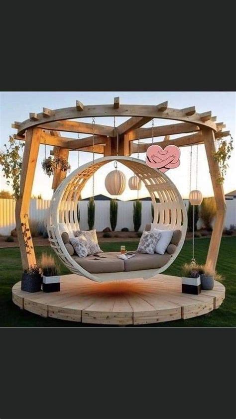 An Outdoor Swing Chair In The Middle Of A Yard With Lights Hanging From