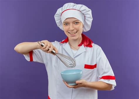 Jovem Sorridente Loira Chef Feminina Em Uniforme De Chef Segurando Uma