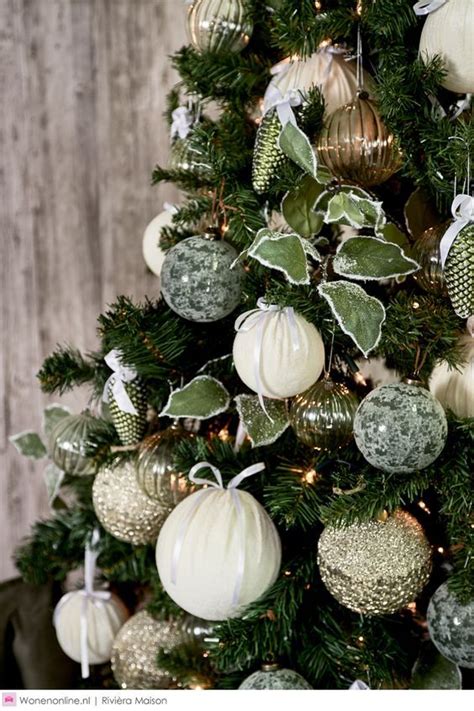 A Christmas Tree Decorated With White And Green Ornaments