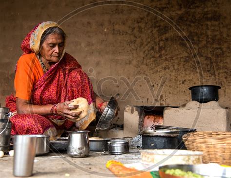 Image Of An Indian Old Woman Making Or Cooking Food In An Ancient Or