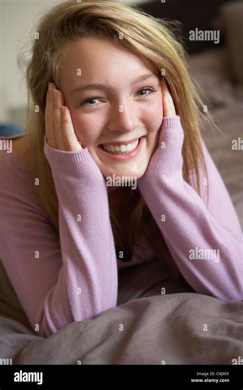 Happy Teenage Girl Sitting In Bedroom Stock Photo Alamy