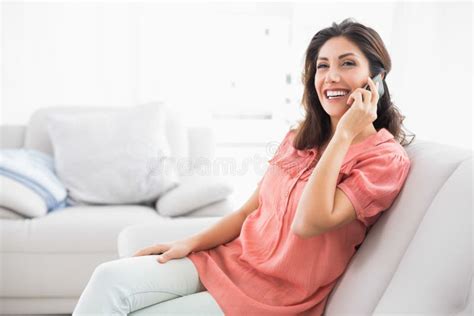 Happy Brunette Sitting On Her Sofa On The Phone Stock Photo Image Of Happy Adult