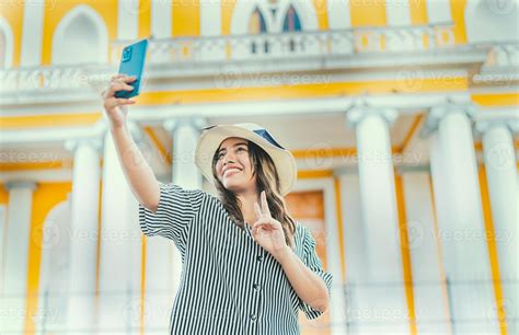 Young Tourist Woman With Hat Taking Selfie In A Square Selfies And