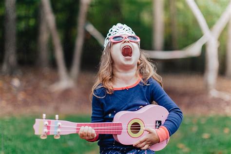 "Funny Young Girl Playing A Toy Guitar And Howling" by Stocksy ...