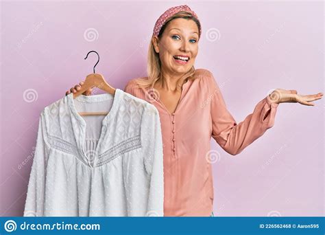 Middle Age Caucasian Woman Holding Clothes Hanger Celebrating Achievement With Happy Smile And