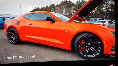 An Orange Sports Car With Its Hood Open