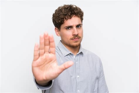 Premium Photo Blonde Man Over Isolated White Wall Making Stop Gesture