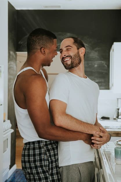 Casal gay abraçando na cozinha Foto Premium