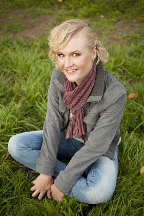 De Blonde Zit Op Het Gras Stock Afbeelding Image Of Geraspt 23825287