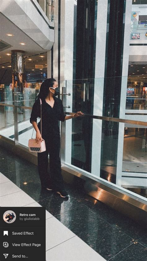 A Woman Is Standing In Front Of A Glass Door With Her Hand On The Handle