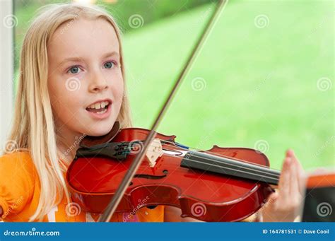 Joyeuse Petite Fille Blonde Jouant Du Violon Sur Fond Vert Flou Image