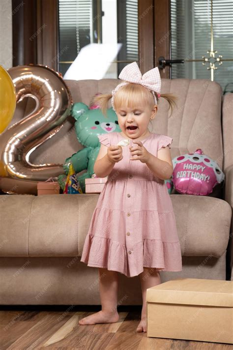 Premium Photo A Twoyearold Girl Inflates A Balloon On Her Birthday