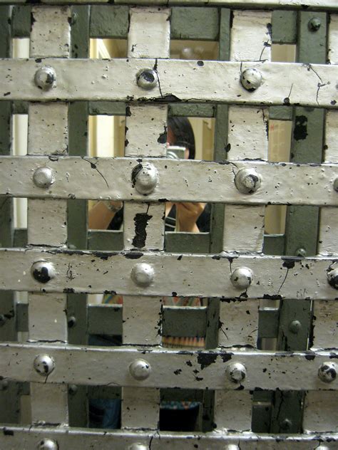 the reflection of a person in a mirror with holes and rivets on it