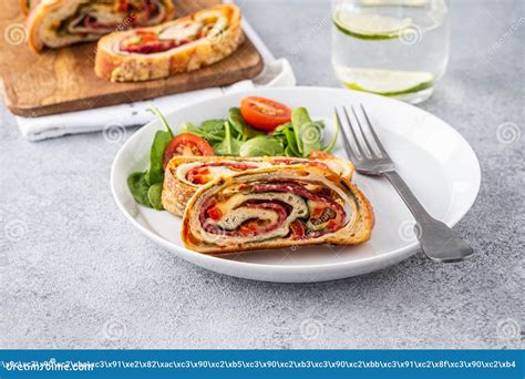 Italian Food Pizza Roll Stromboli With Cheese Salami Spinach And Red Pepper A Light Background